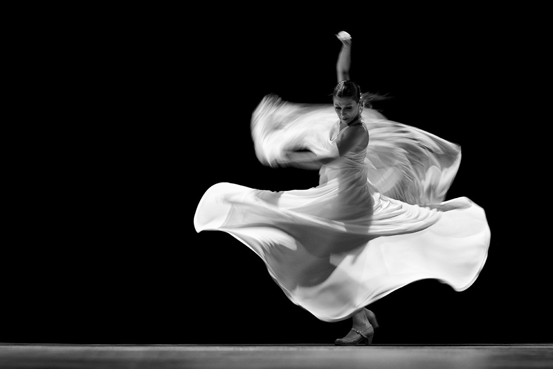 Una bailarina gira con una falda amplia en movimiento.